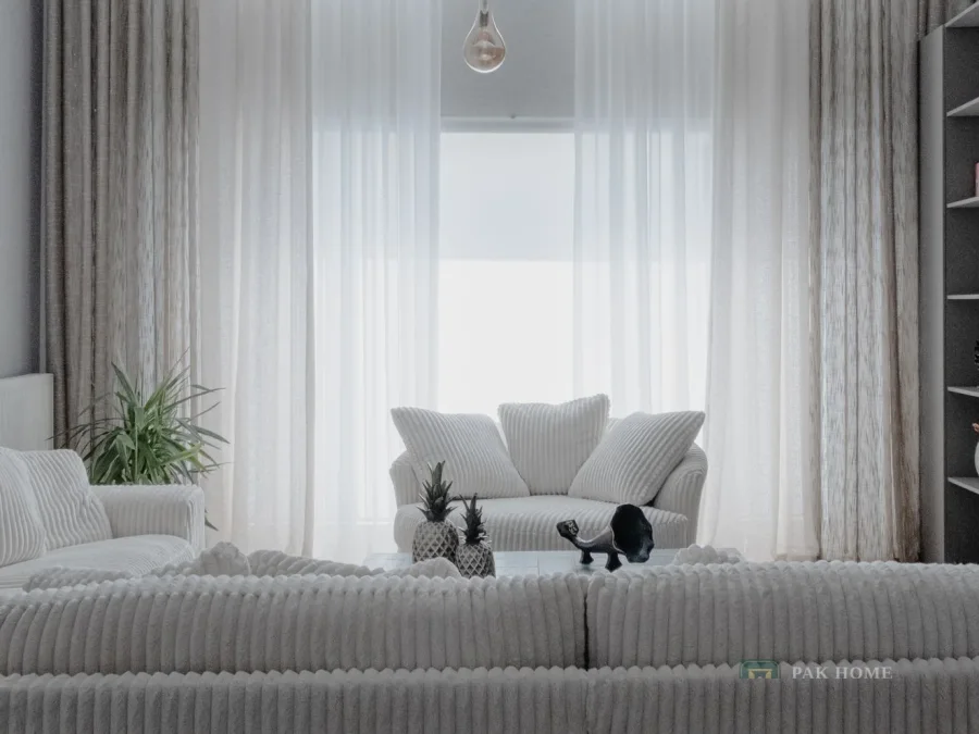 Sheer curtains filtering daylight across a wide living room window